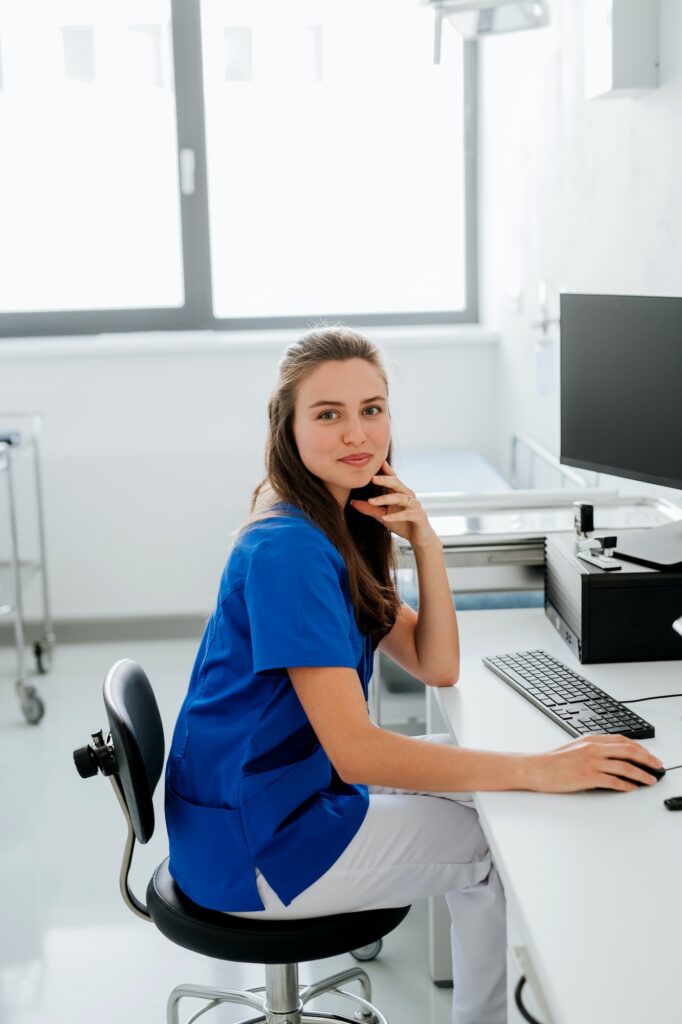 Young woman doctor sitting at hospital office desk.