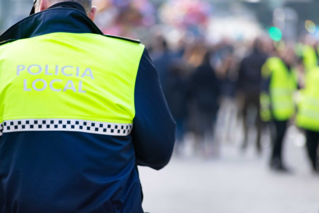 Closeup shot of a police officer with "local police" written on the uniform in Spanish